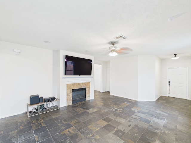 1035 Turnberry Park Ln, Spring, TX 77373 - unfurnished living room with a tile fireplace, stone finish floors, ceiling fan, and baseboards
