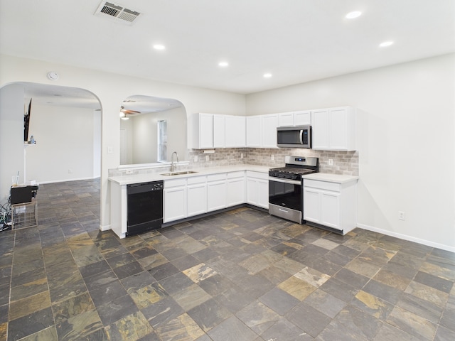 1035 Turnberry Park Ln, Spring, TX 77373 - kitchen featuring stainless steel appliances, arched walkways, light countertops, a sink, and recessed lighting