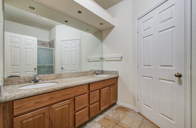 9400 Bellaire Blvd Unit 112, Houston, TX 77036 - bathroom featuring double vanity, a shower with door, and baseboards