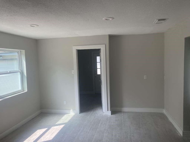 529 Brandon Rd, Conroe, TX 77302 - spare room with a textured ceiling, light wood finished floors, and baseboards