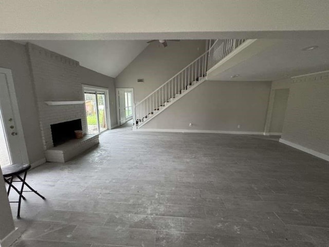 529 Brandon Rd, Conroe, TX 77302 - unfurnished living room with a fireplace, stairs, baseboards, high vaulted ceiling, and wood finished floors