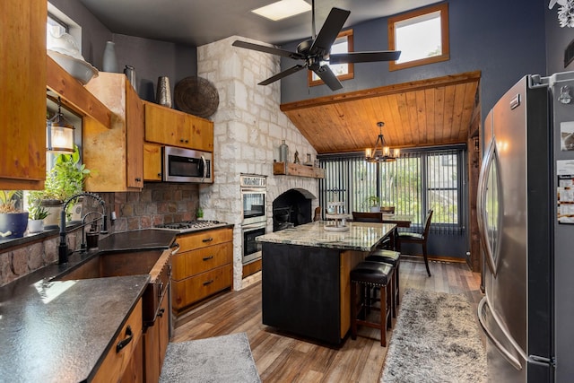 22 Indian Creek Loop, Kerrville, TX 78028 - kitchen with appliances with stainless steel finishes, brown cabinets, a kitchen island, plenty of natural light, and high vaulted ceiling
