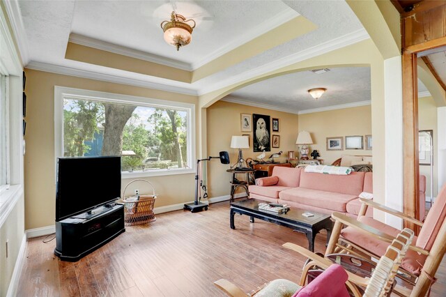 30523 Plantation Dr Unit 37, Damon, TX 77486 - living room with arched walkways, baseboards, wood-type flooring, crown molding, and a raised ceiling