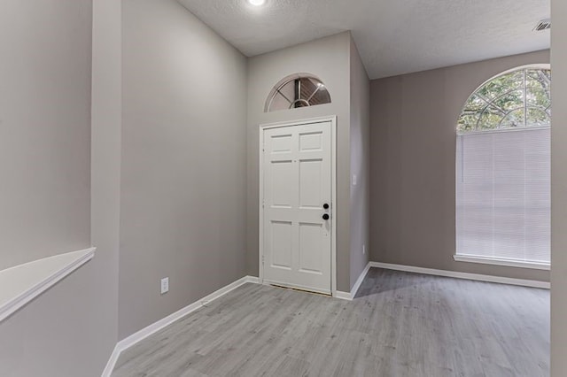 3626 Liles Ln, Humble, TX 77396 - entryway with light wood finished floors, baseboards, and a textured ceiling