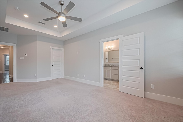 2022 Tarfite Pl, Houston, TX 77077 - unfurnished bedroom with light colored carpet, baseboards, recessed lighting, a tray ceiling, and ensuite bath