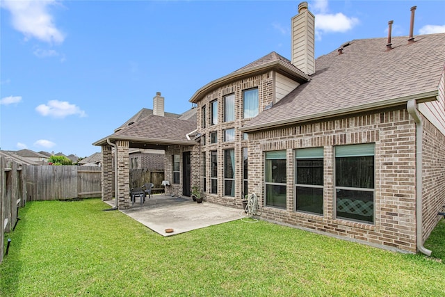 16714 Radiant Lilac Trl, Cypress, TX 77433 - back of property with a chimney, roof with shingles, brick siding, and a patio area