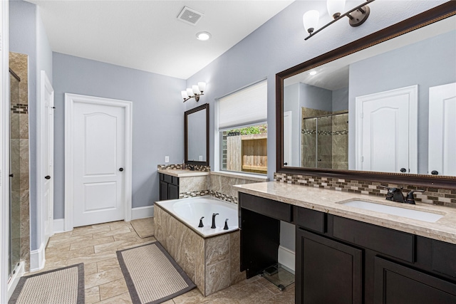 16714 Radiant Lilac Trl, Cypress, TX 77433 - bathroom featuring a stall shower, two vanities, a bath, baseboards, and backsplash