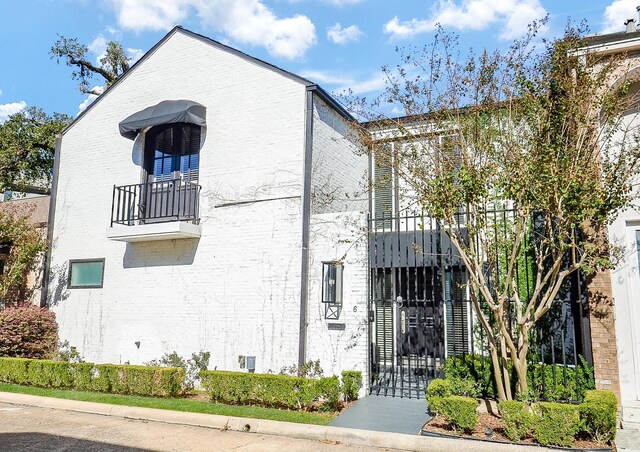 6 River Hollow Ln, Houston, TX 77027 - view of front of home with brick siding, a balcony, and a gate
