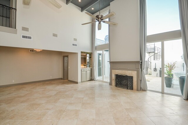 6 River Hollow Ln, Houston, TX 77027 - unfurnished living room with a towering ceiling, ceiling fan, a premium fireplace, baseboards, and stairway