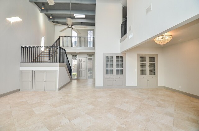 6 River Hollow Ln, Houston, TX 77027 - unfurnished living room with a ceiling fan, a towering ceiling, stairs, a chandelier, and tile patterned floors