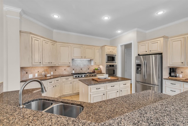 25607 Ryans Creek Ct, Katy, TX 77494 - kitchen with stainless steel appliances, cream cabinetry, a sink, ornamental molding, and recessed lighting
