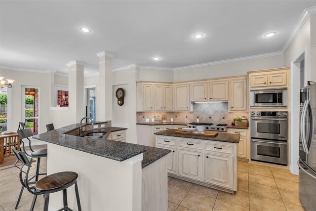 25607 Ryans Creek Ct, Katy, TX 77494 - kitchen with a sink, stainless steel appliances, a center island, a breakfast bar, and backsplash