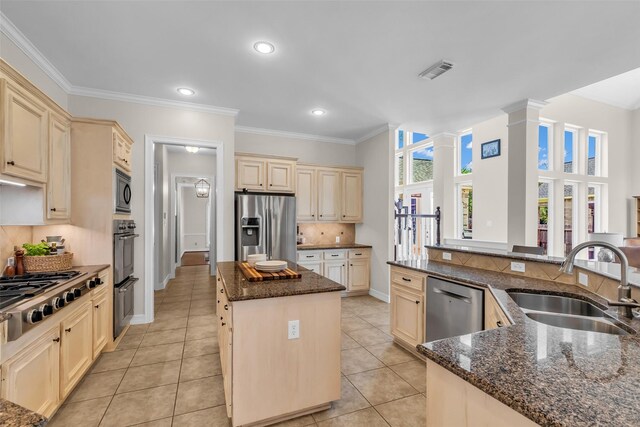 25607 Ryans Creek Ct, Katy, TX 77494 - kitchen with a sink, cream cabinets, stainless steel appliances, a center island, and ornate columns
