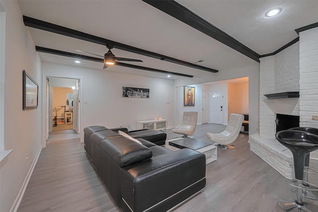 12602 Westleigh Dr, Houston, TX 77077 - living room with light wood-type flooring, a brick fireplace, baseboards, ceiling fan, and beam ceiling