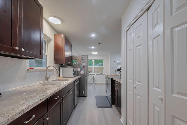 12602 Westleigh Dr, Houston, TX 77077 - kitchen with appliances with stainless steel finishes, a sink, light wood finished floors, decorative backsplash, and dark brown cabinets