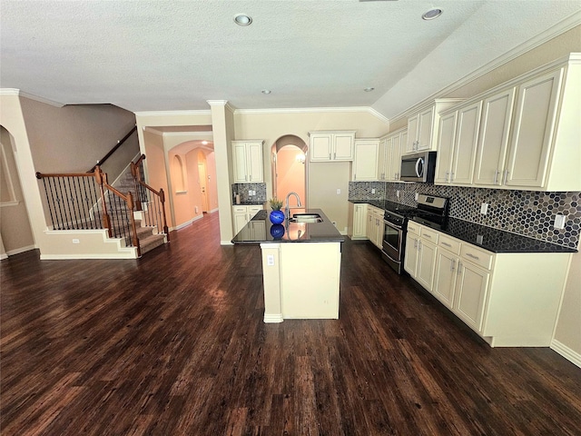 23122 Biddle Dr, Porter, TX 77365 - kitchen with stainless steel appliances, arched walkways, dark countertops, decorative backsplash, and an island with sink