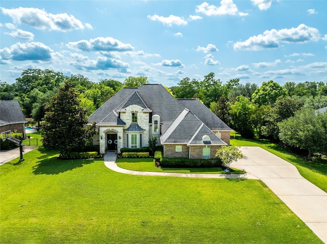 2509 Creektrail Ln, Richmond, TX 77406 - french country inspired facade featuring stone siding, a front yard, and driveway