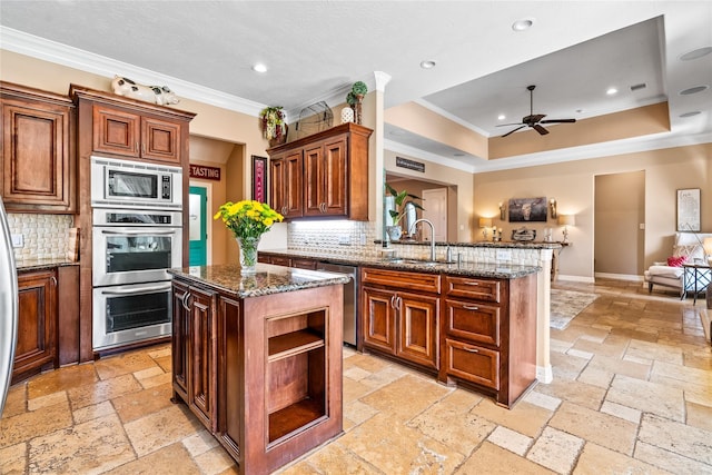 2509 Creektrail Ln, Richmond, TX 77406 - kitchen with stainless steel appliances, stone tile flooring, a sink, crown molding, and a ceiling fan