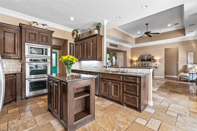2509 Creektrail Ln, Richmond, TX 77406 - kitchen featuring stone tile flooring, appliances with stainless steel finishes, a sink, a ceiling fan, and ornamental molding