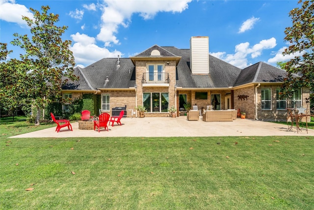 2509 Creektrail Ln, Richmond, TX 77406 - rear view of house featuring brick siding, a patio, a yard, and an outdoor living space with a fire pit