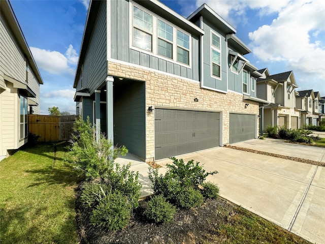 5667 Foggy Vine Ct, Fulshear, TX 77441 - view of front of home with a garage, stone siding, driveway, board and batten siding, and a residential view