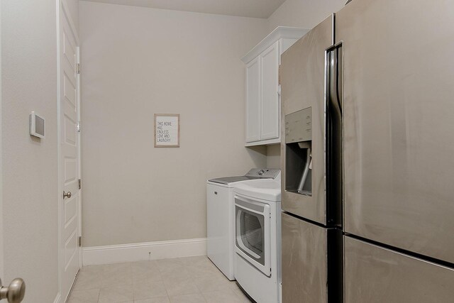 2205 Salt Grass Trl, Conroe, TX 77384 - laundry room featuring cabinet space, washer and dryer, light tile patterned floors, and baseboards