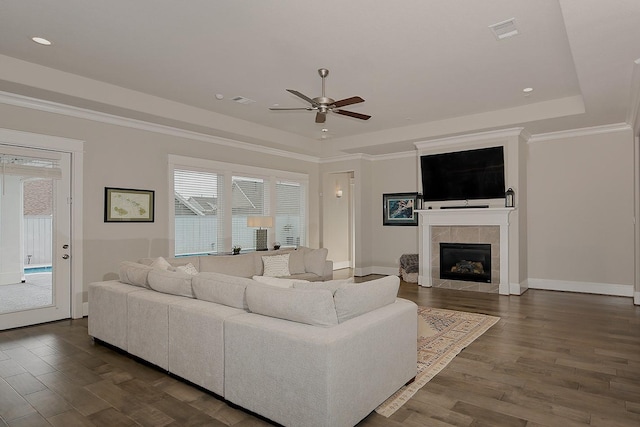 2205 Salt Grass Trl, Conroe, TX 77384 - living area featuring ceiling fan, a tray ceiling, dark wood finished floors, a tile fireplace, and baseboards