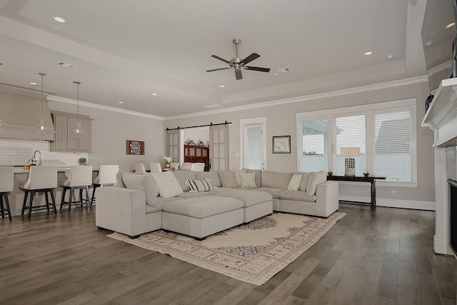 2205 Salt Grass Trl, Conroe, TX 77384 - living area featuring a ceiling fan, dark wood finished floors, a tray ceiling, a barn door, and recessed lighting