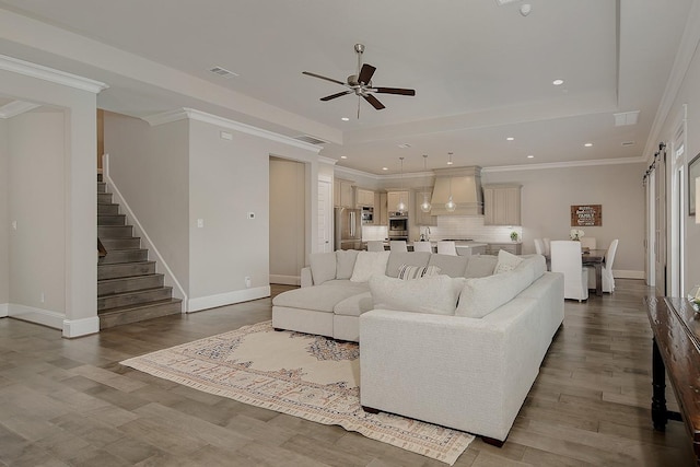 2205 Salt Grass Trl, Conroe, TX 77384 - living room with ceiling fan, stairs, wood finished floors, a tray ceiling, and recessed lighting