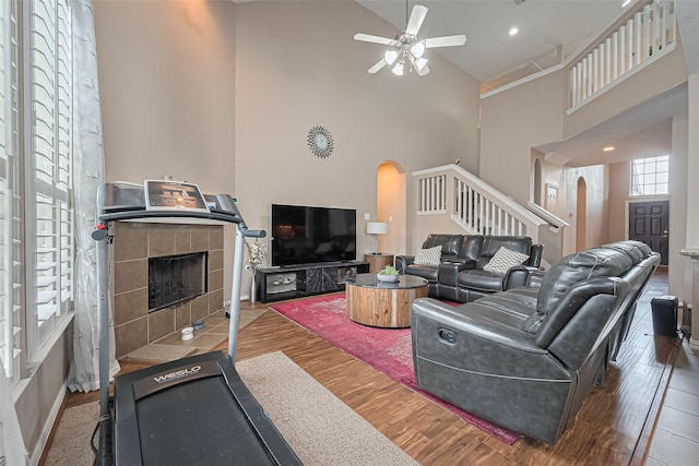 24623 Forest Hiker Ct, Katy, TX 77493 - living room with arched walkways, high vaulted ceiling, stairway, ceiling fan, and wood finished floors