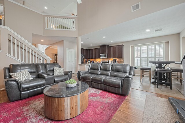 24623 Forest Hiker Ct, Katy, TX 77493 - living area featuring arched walkways, light wood finished floors, a towering ceiling, and recessed lighting