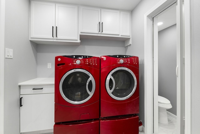 1509 Chestnut Ln, Richmond, TX 77469 - washroom featuring washer and clothes dryer, cabinet space, and marble look tiles