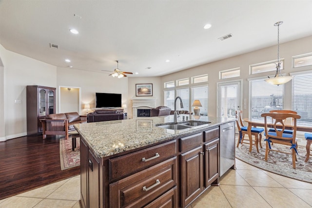 28915 Davenport Dr, Katy, TX 77494 - kitchen with a sink, dishwasher, ceiling fan, light tile patterned floors, and light stone countertops