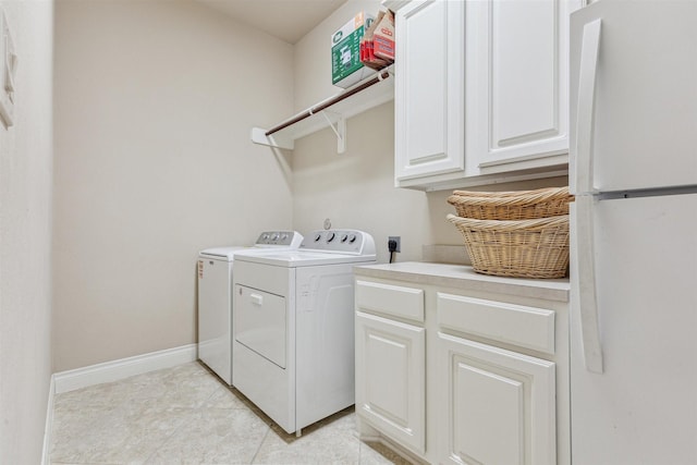 28915 Davenport Dr, Katy, TX 77494 - washroom featuring washer and clothes dryer, cabinet space, baseboards, and light tile patterned flooring