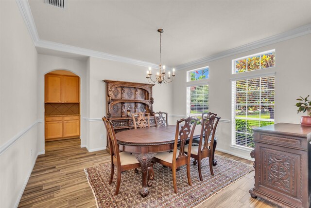 6406 Pine Reserve Dr, Spring, TX 77389 - dining space featuring crown molding, a chandelier, light wood finished floors, and arched walkways