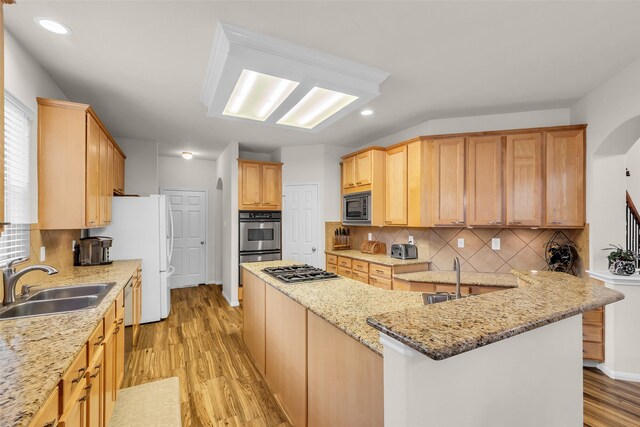6406 Pine Reserve Dr, Spring, TX 77389 - kitchen featuring appliances with stainless steel finishes, light wood finished floors, backsplash, recessed lighting, and light stone countertops
