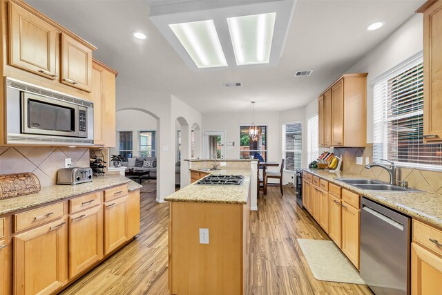 6406 Pine Reserve Dr, Spring, TX 77389 - kitchen featuring stainless steel appliances, a kitchen island, light brown cabinets, arched walkways, and recessed lighting