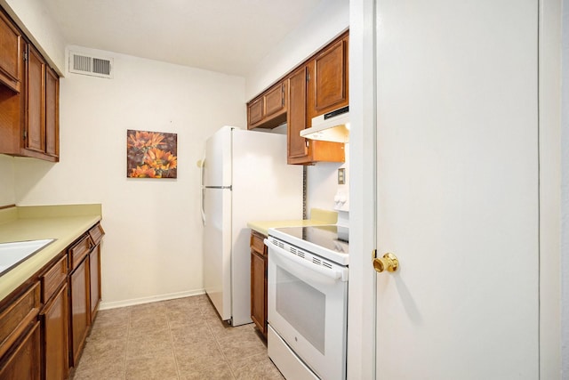 215 Postoffice St Unit 508, Galveston, TX 77550 - kitchen with white appliances, under cabinet range hood, light countertops, and brown cabinets