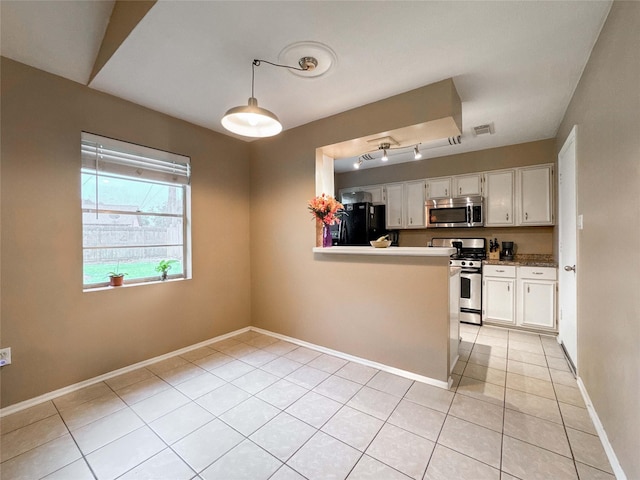 720 E Murray St, Angleton, TX 77515 - kitchen with stainless steel appliances, white cabinetry, light tile patterned floors, a peninsula, and baseboards