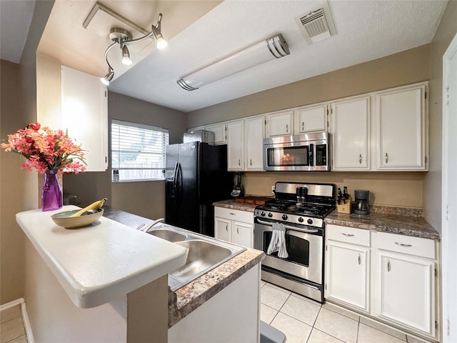 720 E Murray St, Angleton, TX 77515 - kitchen with appliances with stainless steel finishes, a sink, white cabinets, and a peninsula