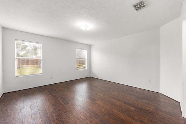 19130 Yaupon Ranch Dr, Cypress, TX 77433 - empty room with dark wood-style flooring, plenty of natural light, and a textured ceiling