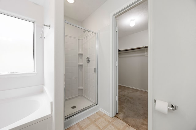 19130 Yaupon Ranch Dr, Cypress, TX 77433 - full bathroom featuring a walk in closet, a shower stall, a garden tub, and tile patterned floors
