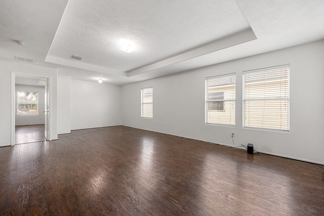 19130 Yaupon Ranch Dr, Cypress, TX 77433 - spare room featuring a tray ceiling, dark wood-style floors, a textured ceiling, and a smoke detector