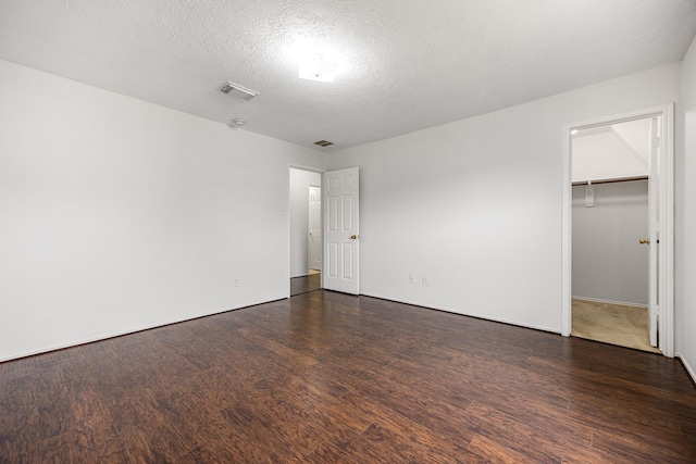 19130 Yaupon Ranch Dr, Cypress, TX 77433 - unfurnished bedroom with dark wood-type flooring, a textured ceiling, a spacious closet, and a closet