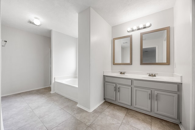 19130 Yaupon Ranch Dr, Cypress, TX 77433 - bathroom featuring double vanity, a bath, a textured ceiling, tile patterned floors, and baseboards