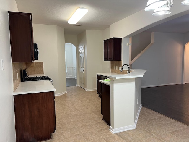 20314 Paso Fino Dr, Humble, TX 77338 - kitchen with arched walkways, gas range oven, light countertops, and decorative backsplash