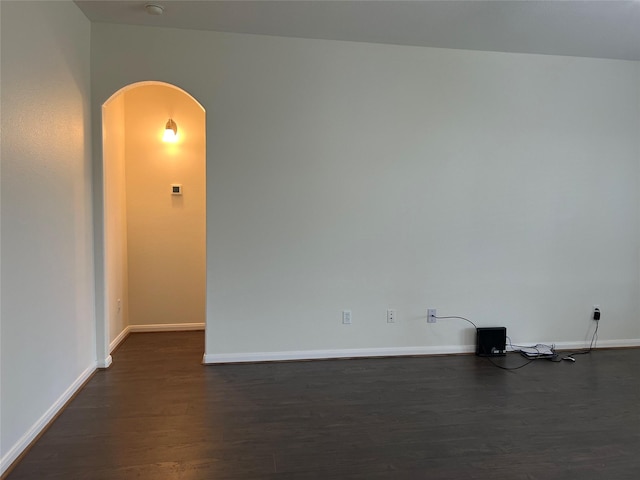 20314 Paso Fino Dr, Humble, TX 77338 - spare room featuring arched walkways, dark wood-style flooring, and baseboards