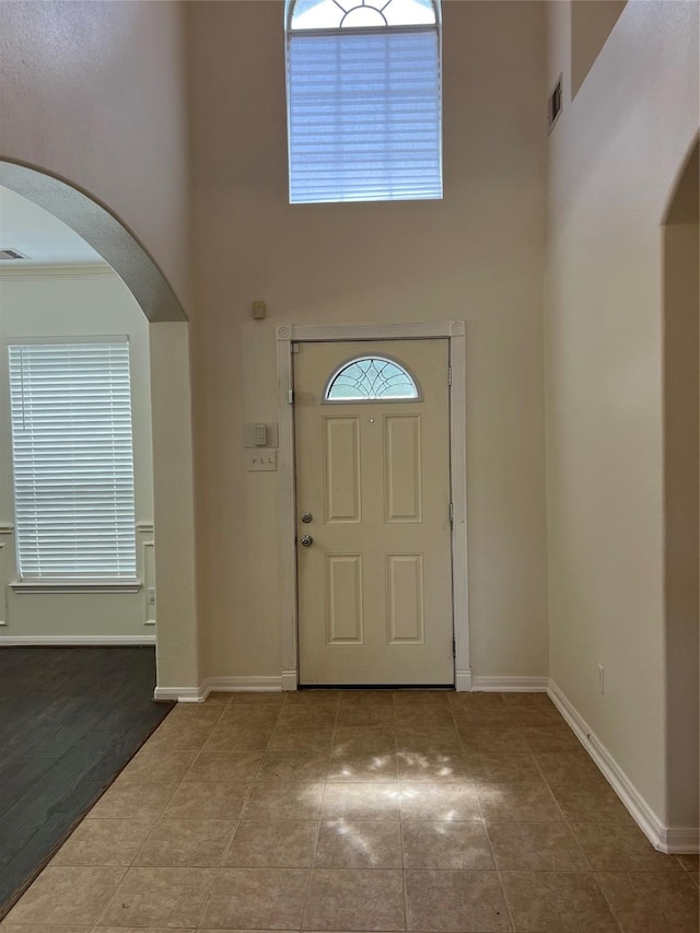 20314 Paso Fino Dr, Humble, TX 77338 - foyer entrance with a high ceiling, arched walkways, baseboards, and tile patterned floors