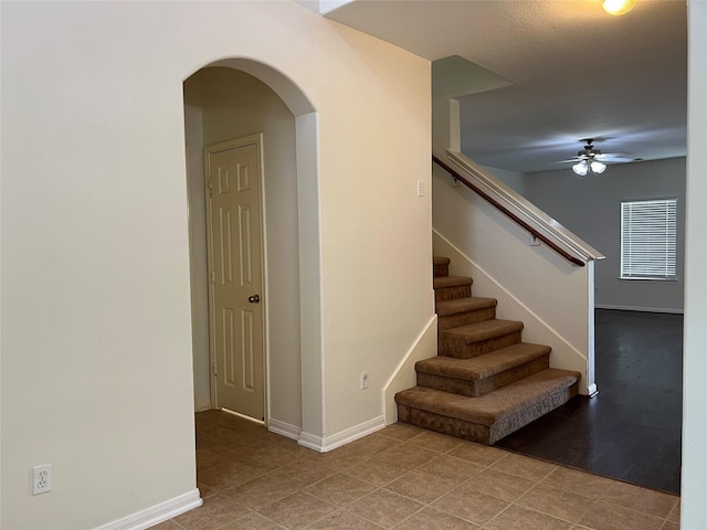 20314 Paso Fino Dr, Humble, TX 77338 - staircase with arched walkways, ceiling fan, baseboards, and tile patterned floors