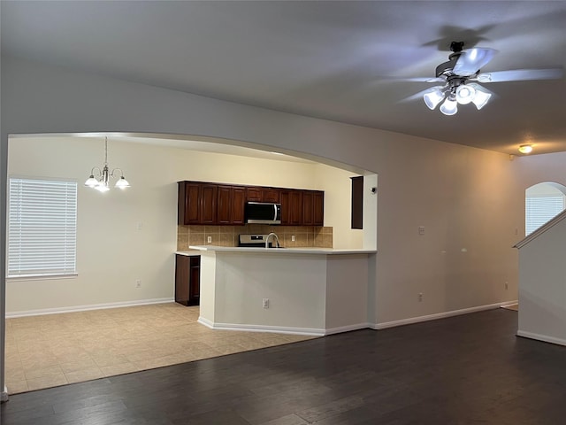 20314 Paso Fino Dr, Humble, TX 77338 - kitchen with stainless steel appliances, ceiling fan, light wood-style floors, light countertops, and arched walkways